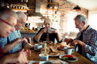 Senior people sitting at dining table together having breakfast