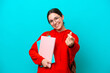 © luismolinero - Young student caucasian woman isolated on blue background making money gesture