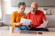 Stressed Senior Couple Checking Financial Papers And Planning Budget At Home