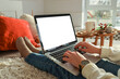 © shine.graphics - Young woman work on laptop computer with blank display screen with mockup copy space. Modern home living room interior design. Christmas, New Year decorated workspace