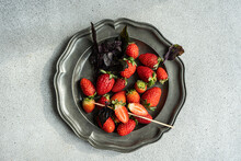 Overhead View Of Fresh Strawberries And Purple Basil On A Pewter Plate