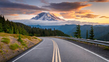 Road Leading Towards Mount Rainier Or Tahoma In Cascades Range With Sunset Clouds Hovering Low In Sky
