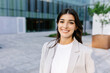 © Xavier Lorenzo - Happy portrait of young businesswoman standing over modern company office building