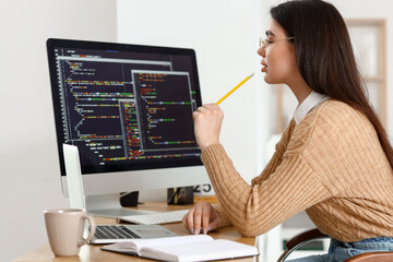 Young female programmer working in office