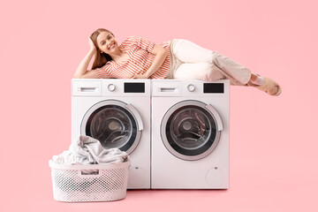 Canvas Print - Pretty young woman lying on washing machines against pink background