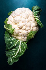 Wall Mural - Fresh organic white cauliflower cabbage with leaves on old rustic green table background, top view