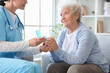 © Pixel-Shot - Senior woman with nurse taking pills at home