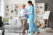 Senior woman with walking stick and nurse at home