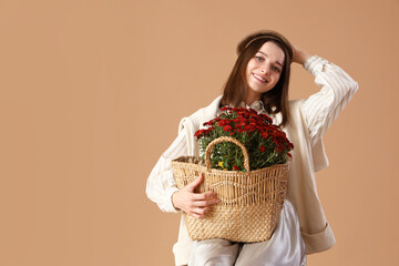 Sticker - Young woman with chrysanthemum flowers on beige background