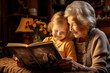 Grandmother and granddaughter watching old photo album at home. Senior woman showing to child black and white retro photos. Retired person and kid happy together.