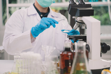 scientist looking through a microscope aloe vera for testing, Is a research and development in beauty, medicine and Herb medicine with herbal organic natural in the laboratory.