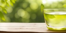 Glass Of Fresh Green Tea On Wooden Table Against Blurred Background, Closeup