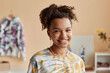 © Seventyfour - Happy young woman in tie dye t-shirt standing in front of camera in workshop, craft studio or atelier creating new stylish and trendy attire