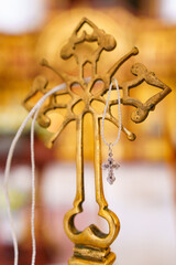 Sticker - A silver pectoral cross on a string on a large gold cross of the baptismal font.