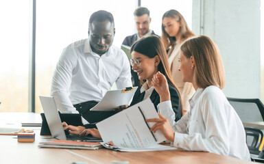 Wall Mural - Wireless device on the table, laptop. Group of office workers are together indoors