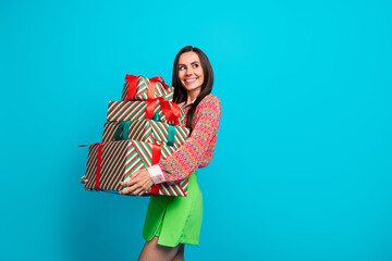 Sticker - Photo portrait of pretty young girl hold gifts pile look empty space wear trendy green skirt isolated on cyan color background