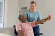 © Wavebreak Media - Caucasian female physiotherapist and senior african american woman in wheelchair with weights