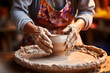 Hands of senior woman in a pottery workshop shape clay.