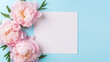Elegant feminine wedding or birthday flat lay composition with pink peonies floral bouquet. Blank paper card, mockup, invitations. Flat-lay, top view on  pale blue background.