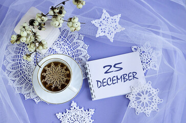 Calendar for December 25: a cup of tea with a decorative snowflake on a lace napkin, the name of the month December in English, the numbers 25