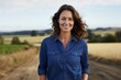 © CogniLens - Portrait of a happy woman in her 30s sporting a versatile denim shirt against a quiet countryside landscape. AI Generation