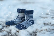 a woollen pair of socks on a snowy cold frosty snow surface in winters