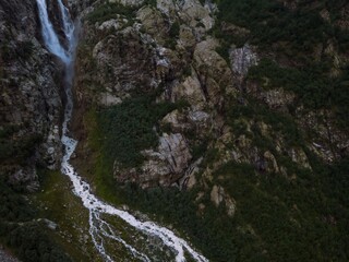 Wall Mural - Aerial panorama of a waterfall among the high Caucasian mountains, Mount Ushba in the background. Valley in the city of Mazeri. Stormy flow of mountain river Dolra. Summer vacation, hiking in Georgia