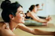 © Flamingo Images - Woman smiling during yoga class