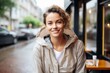 © CogniLens - Portrait of a smiling woman in her 30s wearing a lightweight packable anorak against a serene coffee shop background. AI Generation