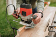 A man works with a wood router. Carpentry, woodworking, furniture manufacturing. Carpentry concept.