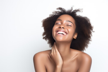 Wall Mural - Portrait of a young smiling black woman touching her flawless glowy skin on soft white background, skincare concept