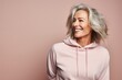 Portrait of a blissful woman in her 50s dressed in a comfy fleece pullover against a pastel or soft colors background. AI Generation