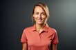 Portrait of a grinning woman in her 30s wearing a sporty polo shirt against a minimalist or empty room background. AI Generation