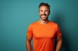 Portrait of a grinning man in his 30s wearing a moisture-wicking running shirt against a solid color backdrop. AI Generation