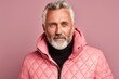 Portrait of a happy man in his 50s sporting a quilted insulated jacket against a solid color backdrop. AI Generation