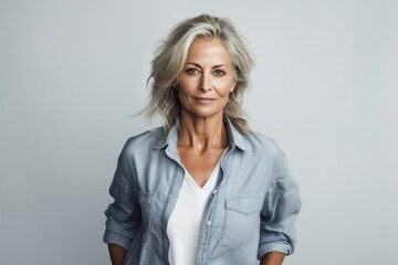 Poster - Portrait of a blissful woman in her 50s sporting a versatile denim shirt against a plain white digital canvas. AI Generation