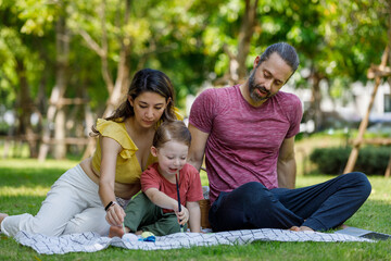 Wall Mural - Happy family day, father, mother, son, Caucasian enjoying watercolor painting and picnic in nature.