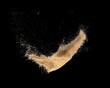 flying brown sugar isolated on black background