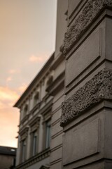 Canvas Print - Vertical close-up of the exterior wall of the building at sunset with a cloudy sky in the background