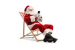 © Ljupco Smokovski - Santa claus sitting at a beach chair and typing on a smartphone