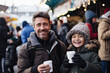 Happy family enjoys winter holiday fun in the Christmas market, spreading joy and festive cheer.