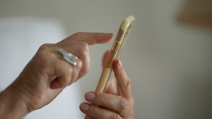 Close-up senior hands holding cellphone device, finger touching screen selecting item online