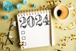 2024 New year resolutions on desk. 2024 goals list with notebook, coffee cup, festive decorations on golden background. Resolutions, plan, goals, checklist, idea concept. New Year 2024 resolutions