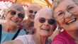 © Ilia - Group of happy grannies making selfie in amusement park.