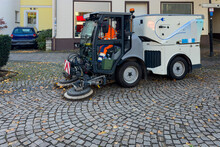 A Street Sweeper Machine Cleaning The Paved Sidewalks. City Street.