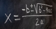 Ecuaciones cuadráticas escrito a mano en una pizarra con tiza, fórmulas matemáticas