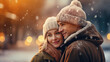 Young couple enjoying life outdoors in winter snowfall. Beautiful woman and handsome man smiling. There is romance in the air. Blurry background.