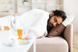 © Prostock-studio - Sick Indian Guy Having Fever Lying On Couch At Home