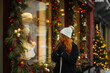 © ADDICTIVE STOCK - Woman admiring holiday window display in winter in Quebec, Canada