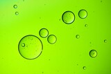 Fototapeta Łazienka - Macro shot of oil bubbles texture on a green background